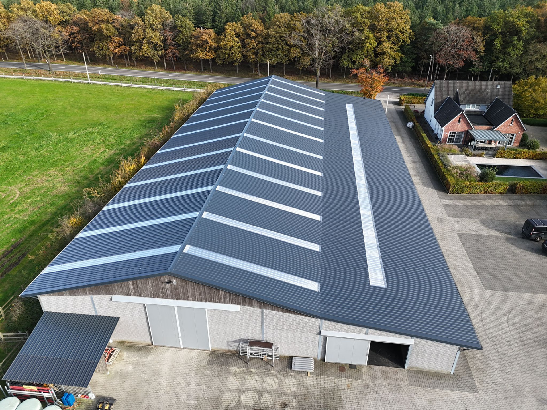 Groot hellend bedrijfsdak met nieuwe donkere dakplaten en lichtstroken